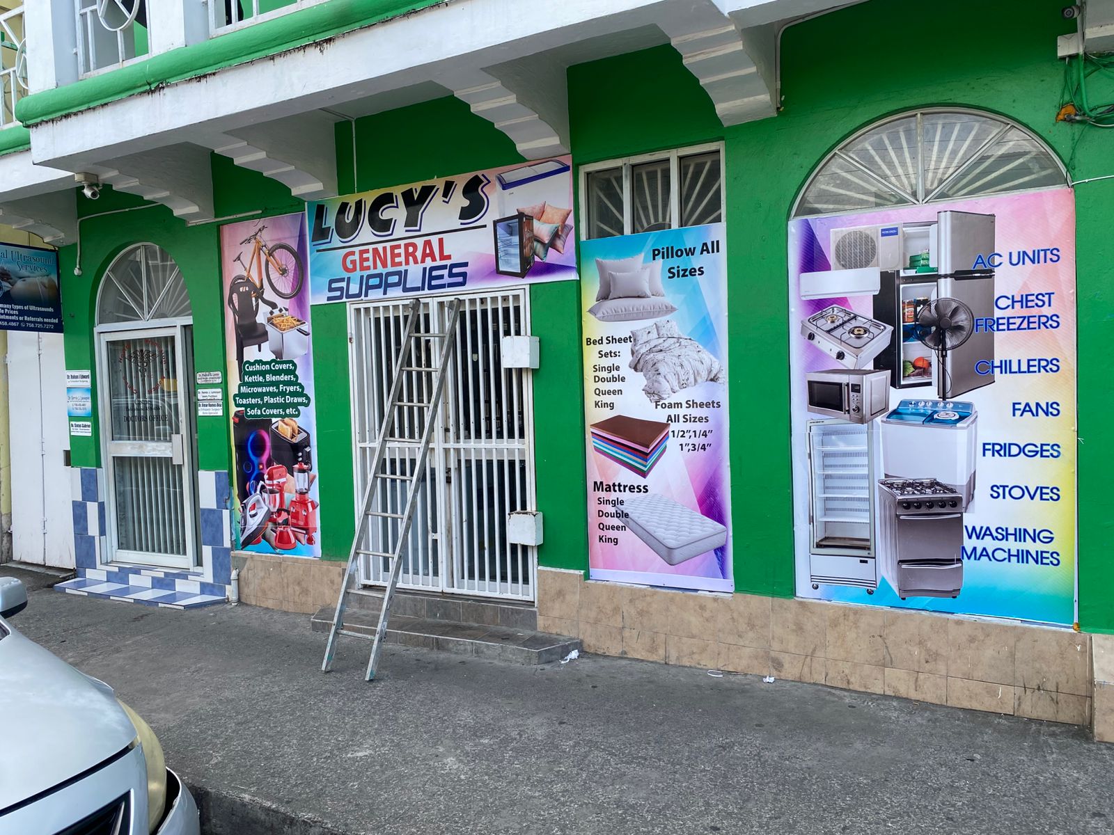 Completed storefront graphics on a green shop facade